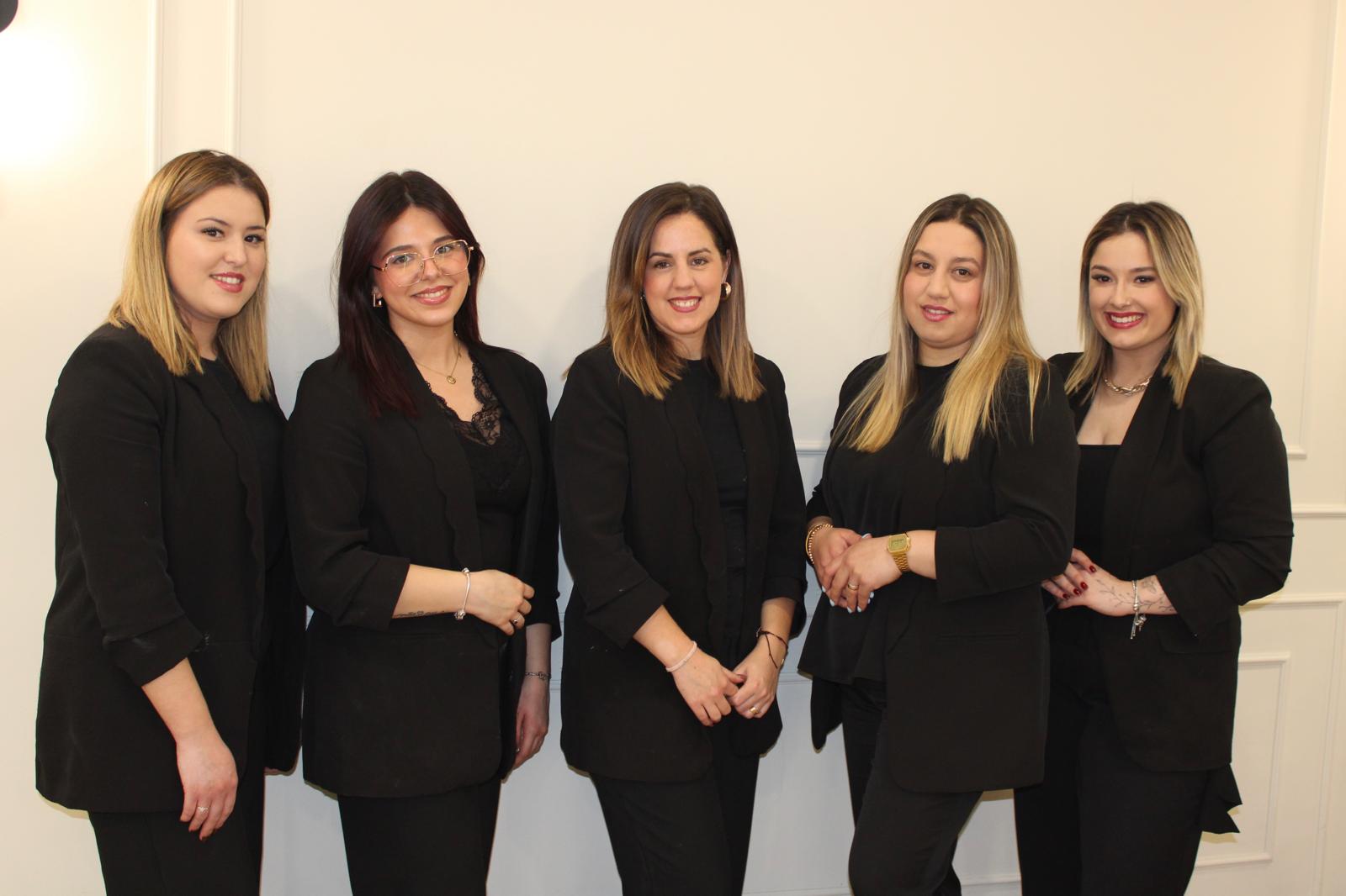 Profissionais de beleza sorrindo e fazendo pose com escovas e tesouras nas mãos