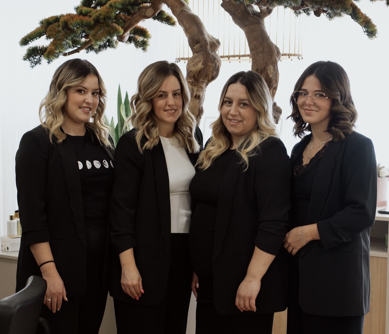 Profissionais de beleza sorrindo e fazendo pose com escovas e tesouras nas mãos