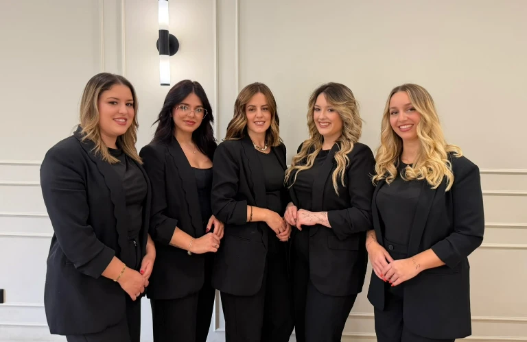 Profissionais de beleza sorrindo e fazendo pose com escovas e tesouras nas mãos